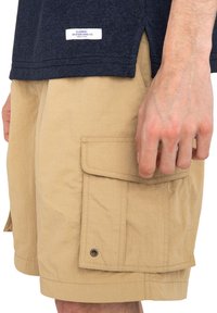 Marineblå T-shirt med Element Skateboard Co. mærke; beige cargo shorts med sidelommer og trykknaplukning; letvægtsstof og afslappet pasform.