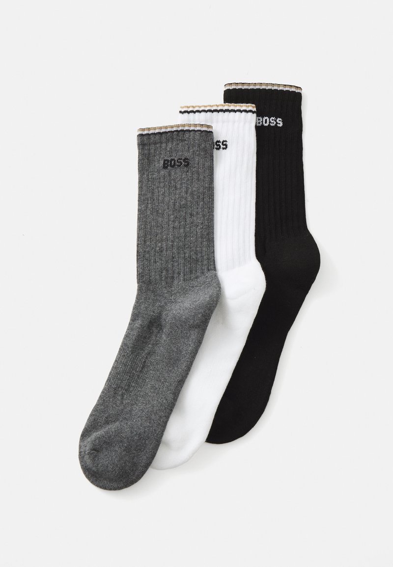 Three pairs of ribbed socks: one gray, one white, and one black. Each features a logo on the cuff and contrasting colored trims.