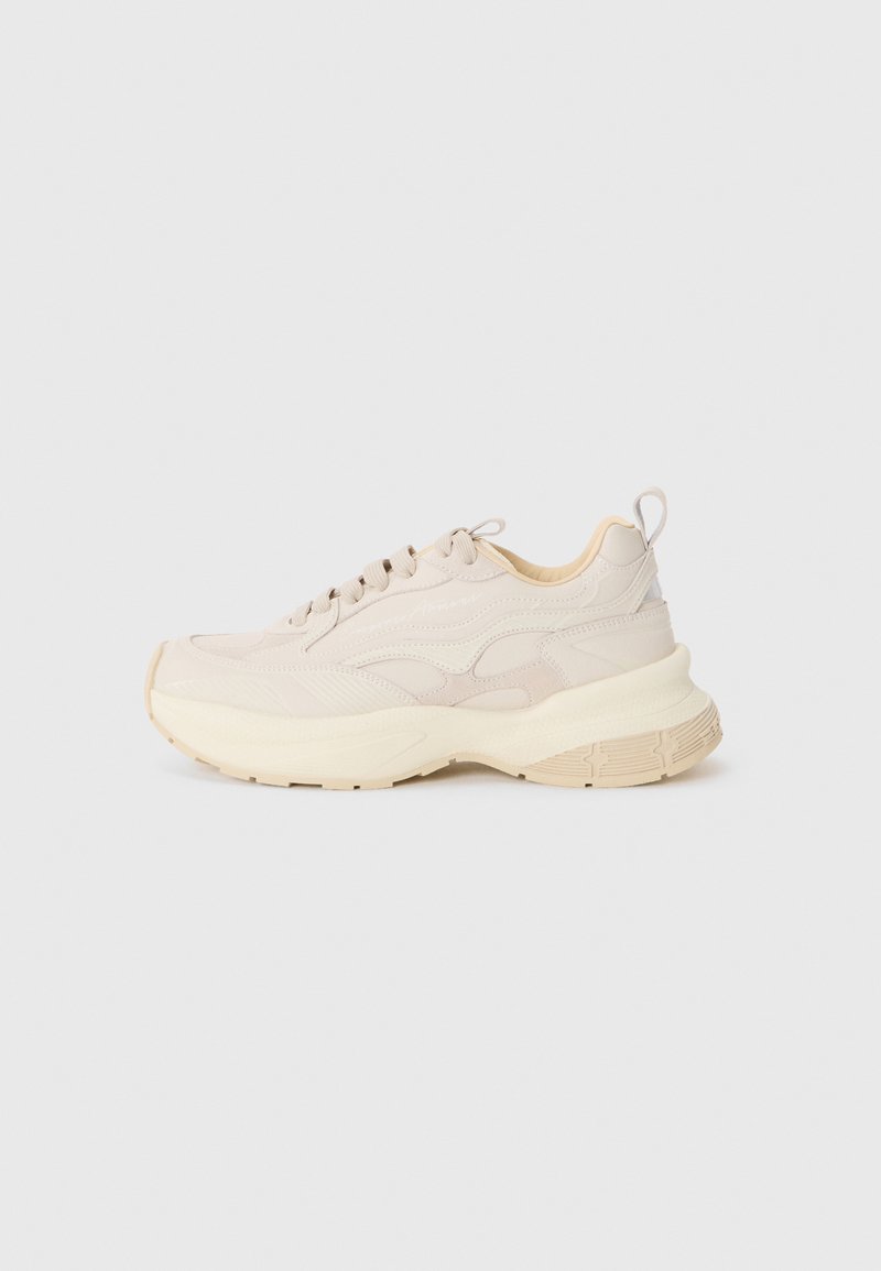 Beige sneakers with smooth upper, textured accents, and chunky off-white sole. Features laces and a loop at the heel for easy wear.