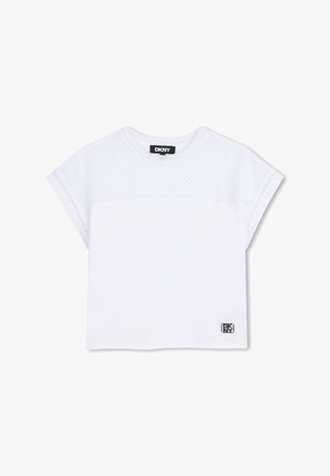 Camiseta blanca de manga corta DKNY con sección superior de malla y sección inferior sólida, con un pequeño parche con el logo de DKNY cerca del dobladillo.