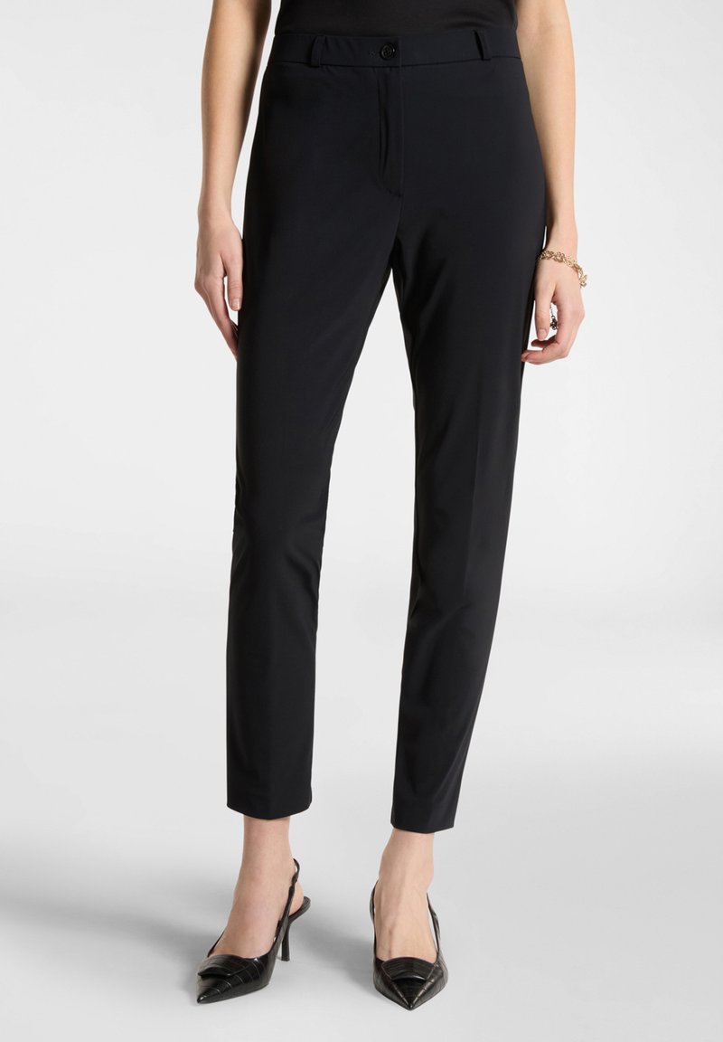 Pantaloni neri su misura con un design aderente, tessuto liscio e chiusura a bottone. Presentano una silhouette slim e una lunghezza cropped.