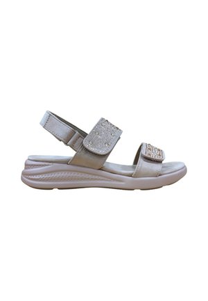 Sandalia beige de punta abierta con suela acolchada, correas ajustables en el tobillo y parte delantera decoradas con pequeñas tachuelas decorativas.