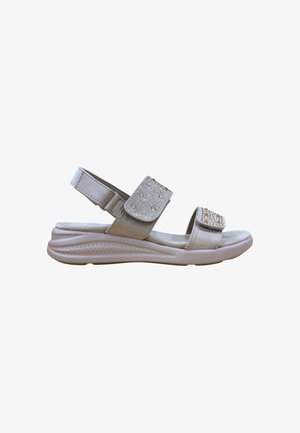 Sandalia beige de punta abierta con suela acolchada, correas ajustables en el tobillo y parte delantera decoradas con pequeñas tachuelas decorativas.