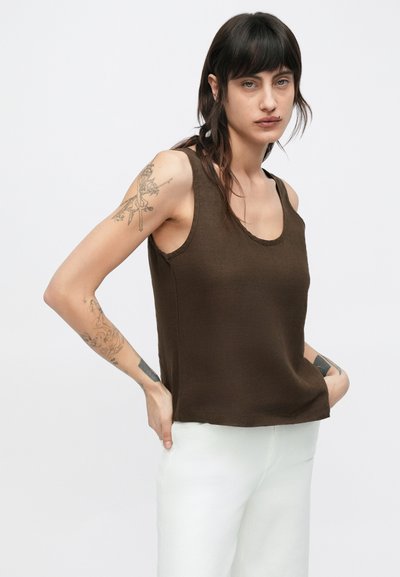 Καφέ αμάνικη μπλούζα από απαλό, υφασμάτινο ύφασμα με στρογγυλή λαιμόκοψη και άνετη εφαρμογή, σε συνδυασμό με λευκό παντελόνι. Καθημερινός σχεδιασμός.