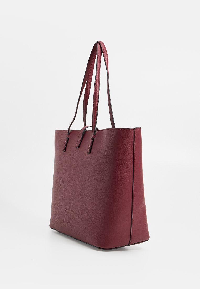 Bolso de mano burdeos con un acabado de cuero sintético texturizado, forma rectangular, doble asa y costuras mínimas para un diseño elegante.