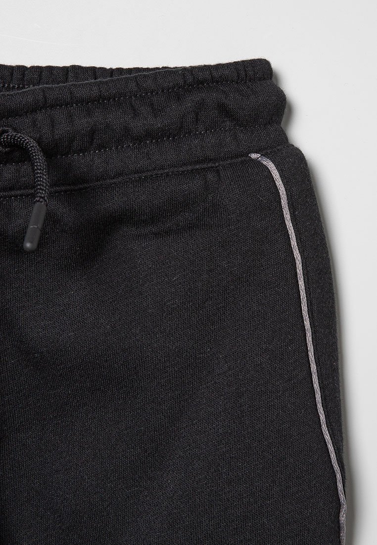 Schwarzer Sweatpants-Bund mit Elastik und Kordelzug, versehen mit seitlicher Naht und hellgrauer Paspelierung auf weißem Hintergrund.