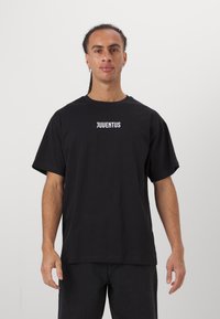 Black cotton t-shirt with short sleeves and a crew neckline, featuring the word "JUVENTUS" in white lettering on the front.