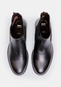Czarne buty wsuwane ze skóry naturalnej z teksturowanym wykończeniem, z elastycznymi bocznymi panelami i małą pętelką ułatwiającą zakładanie.