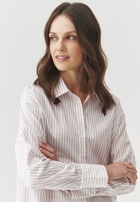 White button-up shirt with light pink vertical stripes. Features a collar and long sleeves with button cuffs. Smooth fabric texture.
