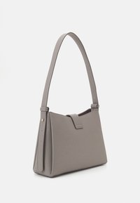 Szara torba syntetyczna o ustrukturyzowanym kształcie, z długim paskiem i zamknięciem na klapę. Teksturowana powierzchnia i minimalistyczne elementy metalowe.