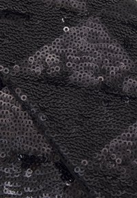 Czarny materiał z cekinami o nachodzącym na siebie wzorze okrągłych cekinów, tworzący teksturowaną powierzchnię o zróżnicowanych odcieniach czerni i błyszczących wykończeniach.