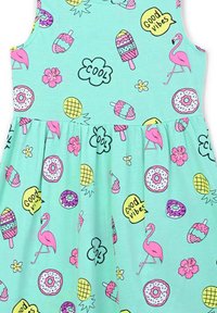 Abito senza maniche di colore verde menta con motivi giocosi che includono fenicotteri, gelati, ciambelle e fiori nei colori rosa, giallo e nero.