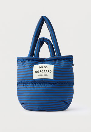 Blauw en zwart gestreepte gevoerde draagtas met twee handvatten en een wit label met de tekst "Mads Nørgaard Copenhagen" aan de voorkant.