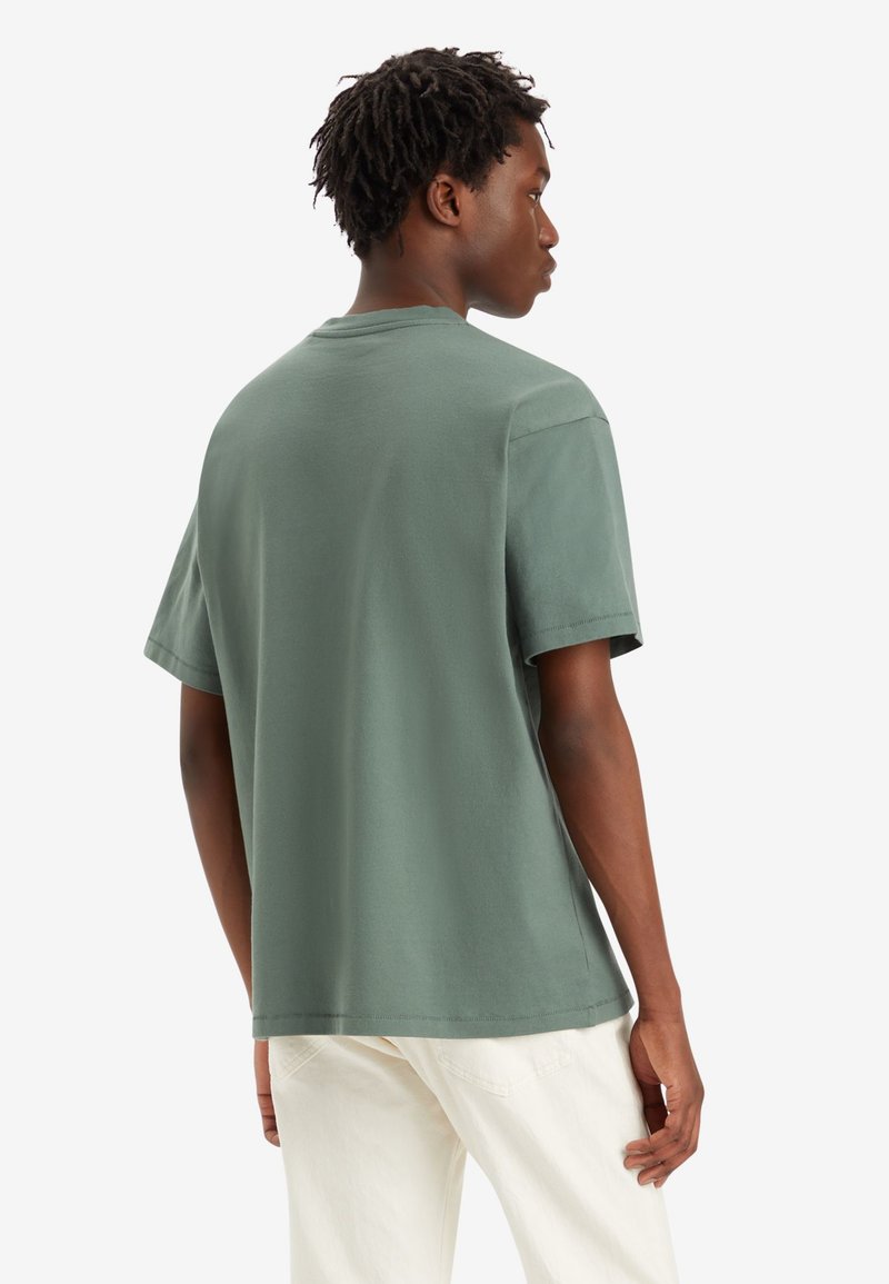 Grünes Baumwoll-T-Shirt mit lässiger Passform, kurzen Ärmeln und Rundhalsausschnitt, das eine glatte Textur und minimale Nähte zeigt.