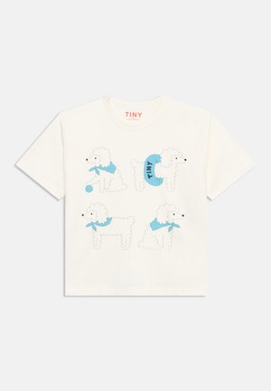 T-shirt blanc à manches courtes avec quatre illustrations de caniches blancs portant des foulards bleus et un tenant une balle bleue.