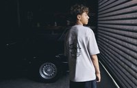 Gray oversized t-shirt with a graphic print on the back, featuring detailed illustrations and text. Soft fabric and relaxed fit visible.