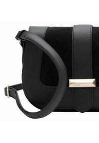 Bolso cruzado negro con acabado de piel texturizada, panel de ante, herrajes en tono dorado y una correa plana con longitud ajustable.