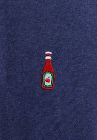 Navy fabric featuring a small embroidered ketchup bottle in red, green, and white with a cherry icon on the label.
