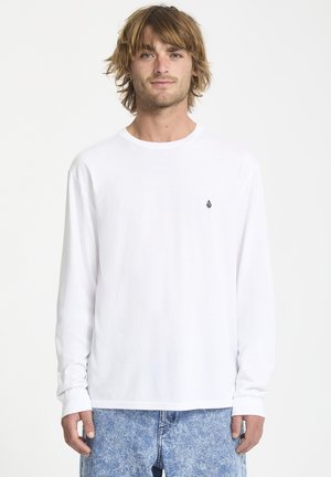 Hvid langærmet t-shirt med rund hals og et lille sort logo på venstre bryst. Stoffet ser glat og let ud.