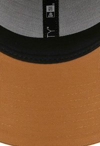 Nahaufnahme eines braunen und schwarzen Baseballmützen-Mannes mit einem grauen Netzinnenfutter und einem New Era-Logo auf dem schwarzen Schweißband.