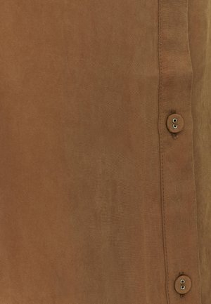 Brauner Stoff mit glatter Textur, mit einer Seitennaht und dekorativen Knöpfen zum Schließen. Das Gesamtdesign ist einfach und minimalistisch.