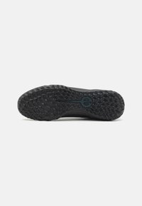 Black sneaker sole with a textured traction pattern and a central logo. The overall shape is elongated with a curved toe and a flat heel.