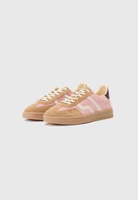 Adidași din suede maro și roz, cu dungi texturate, șireturi crem și tălpi din cauciuc. Prezintă un logo discret pe lateral și o călcâie în contrast.