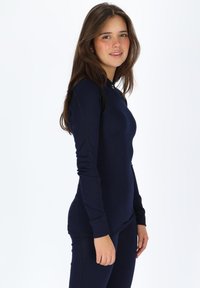Navyblauw aansluitend long sleeve top met geribbelde textuur, voorzien van een hoge hals en slim fit, gecombineerd met bijpassende broeken.