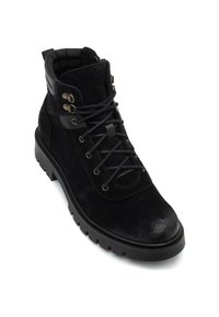 Botín de ante negro con ojales metálicos, cordones negros, cuello acolchado y suela de goma texturizada con un diseño de banda de rodadura resistente.