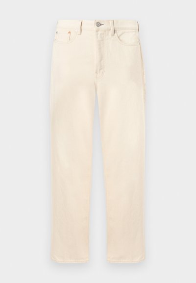 Proste dżinsy w kolorze kremowym z przednim guzikiem i zamkiem błyskawicznym, przednimi i tylnymi kieszeniami oraz szlufkami na pasek, pokazane na jednolitym tle.