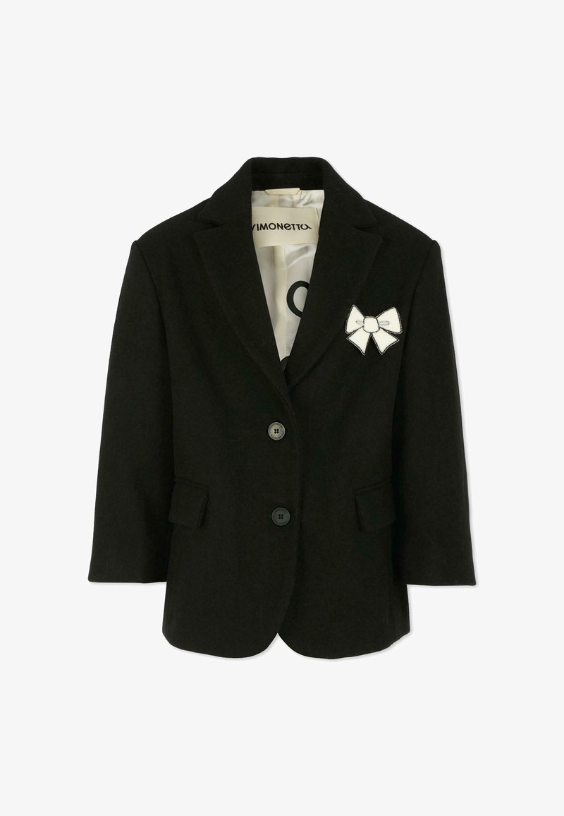 Blazer noir à la forme classique, avec deux boutons, un col noté et un patch en forme de noeud blanc décoratif. Tissu doux avec une texture lisse.