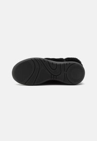 Calzado negro con una suela de goma texturizada. Cuenta con un diseño acolchado, forro de piel de peluche y una puntera redondeada. Marcas en la suela para mejor tracción.