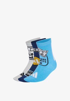 Drei bunte Kniestrümpfe in Blau, Navy und Weiß mit grafischen Designs und Text, nebeneinander auf weißem Hintergrund angeordnet.