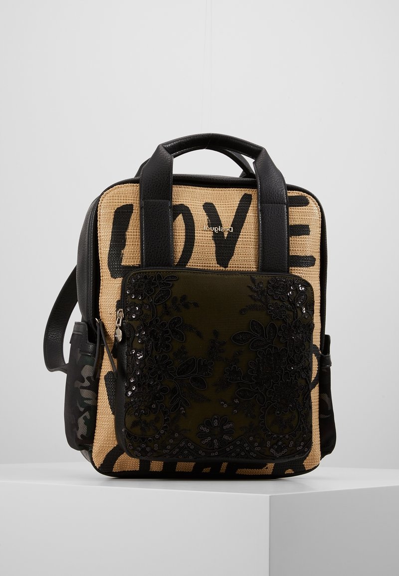 Sac à dos rectangulaire avec poignées noires, panneau avant tissé beige imprimé "LOVE" et poche zippée brodée de fleurs noire à l'avant.