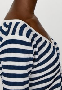 Sweter w paski z poziomymi, granatowo-białymi pasami, o żebrowanej fakturze, szerokim, odsłaniającym ramiona dekoltem i dopasowanym kroju.