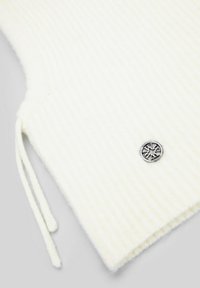 Witte gebreide trui stof met geribbelde textuur. Voorzien van een metalen logo-accent en trekkoorden aan de zijkant. Zachte en lichte uitstraling.