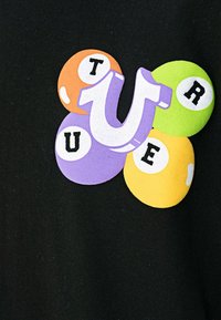 Zwarte stof met een kleurrijke afbeelding van vier biljartballen in oranje, paars, groen en geel, en de letters "TRUE".