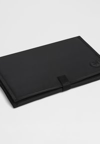 Černé pouzdro na notebook z nylonu s hladkou texturou, vybavené uzávěrem na suchý zip a kulatým logem v pravém dolním rohu.