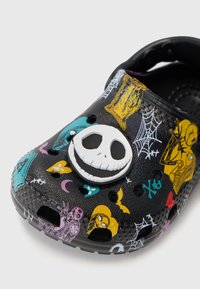 Zueco de plástico negro con gráficos coloridos de temática de Halloween y un prominente detalle de la cara blanca de Jack Skellington en la parte frontal.
