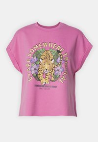 Camisa rosa de manga corta con un gráfico frontal de un leopardo caminando, hojas tropicales, flores moradas y el texto "Escapa a un lugar tropical".