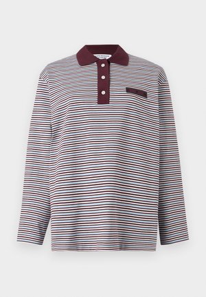 Polo de manga larga con rayas horizontales blancas y púrpura oscuro, cuello púrpura oscuro, tres botones blancos y pequeño detalle de parche en el pecho.