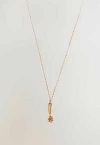 Collier en or avec un pendentif en forme de poisson, présentant des écailles texturées et une frange décorative, suspendu à une chaîne délicate ornée de petites perles.