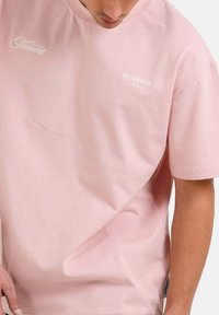 Camiseta de algodón de manga corta en color rosa claro con "Nament" y "SIXTHJUNE PARIS" bordados en blanco. Corte relajado con cuello redondo.