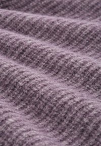 Teksturowana fioletowa tkanina o miękkiej, puszystej powierzchni, z diagonalnym rypsowym wzorem oraz różnymi odcieniami lila i lawendy.