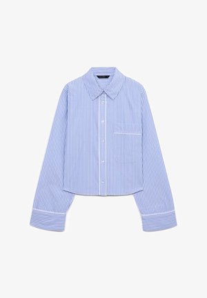 Camicia a righe blu e bianche con colletto a punta, maniche lunghe e una singola tasca sul petto con rifinitura bianca. Design accorciato.