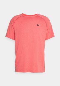 Camiseta deportiva rosa hecha de un tejido ligero y transpirable. Presenta un cuello redondo, mangas cortas y un pequeño logo negro de Nike en el pecho.