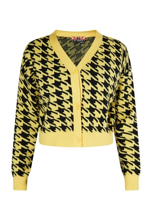 Lyhennetty keltainen neuletakki mustalla houndstooth-kuviolla, jossa on V-pääntie, pitkät hihat ja viisi nappia edessä.
