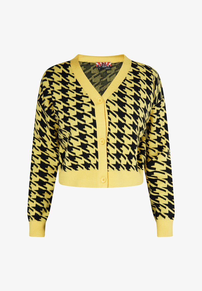 Skratený kardigán v žltej farbe s čiernym houndstooth vzorom, s V-výstrihom, dlhými rukávmi a piatimi gombíkmi vpredu.