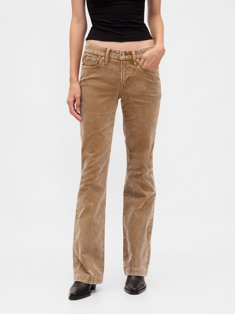 Brown corduroy flared jeans with two front pockets, a button and zip fly, and slight sheen. Paired with black top and boots.