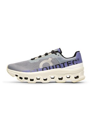 Lightweight running shoes in gray mesh with purple accents, featuring a chunky midsole with cutouts for cushioning and black laces.